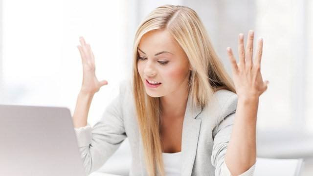 lady sat in an office raising her hands in frustration or stress